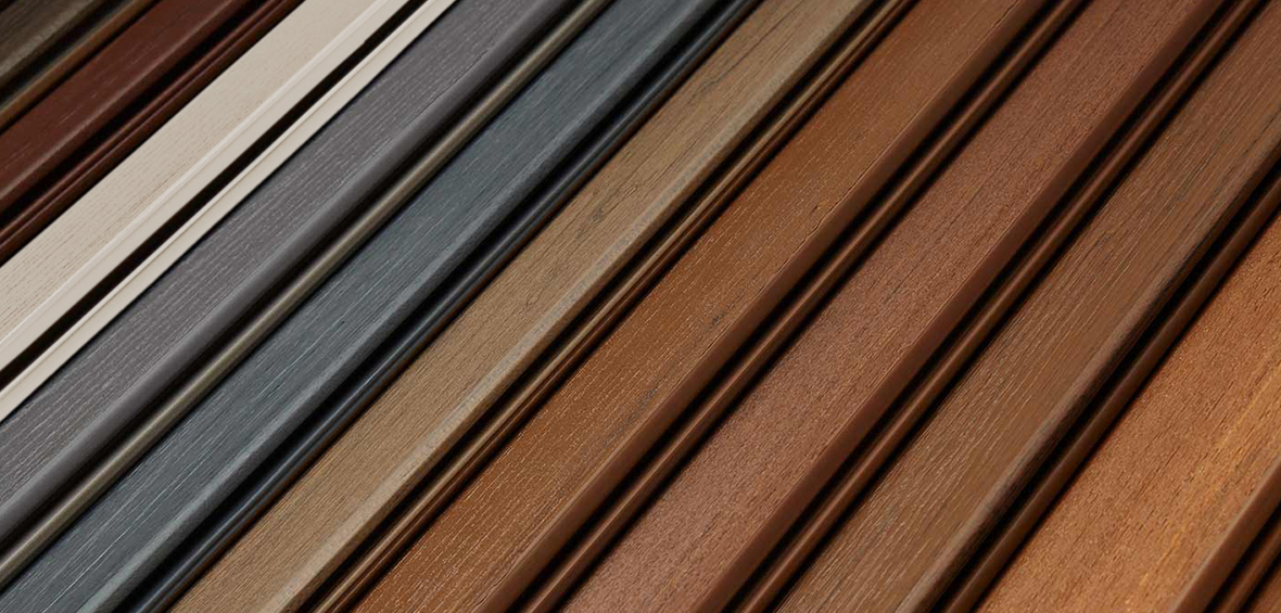 A close up of decking boards showcases a variety of colors, textures, and grain patterns available.