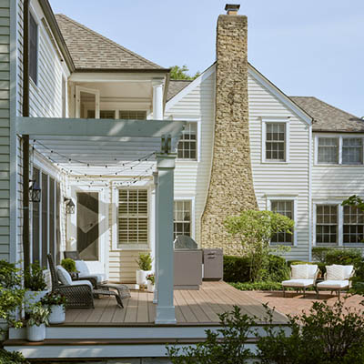 Two tone deck color schemes with a large family home and white pergola over a low deck