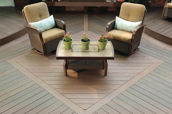 Two tone deck color schemes showcased with two comfy chairs and an end table on a composite deck